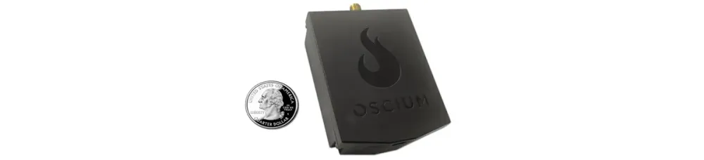 An Oscium Wi-Pry 2500x device for spectrum analysis, shown next to a quarter for scale, featuring a black casing with the Oscium logo.